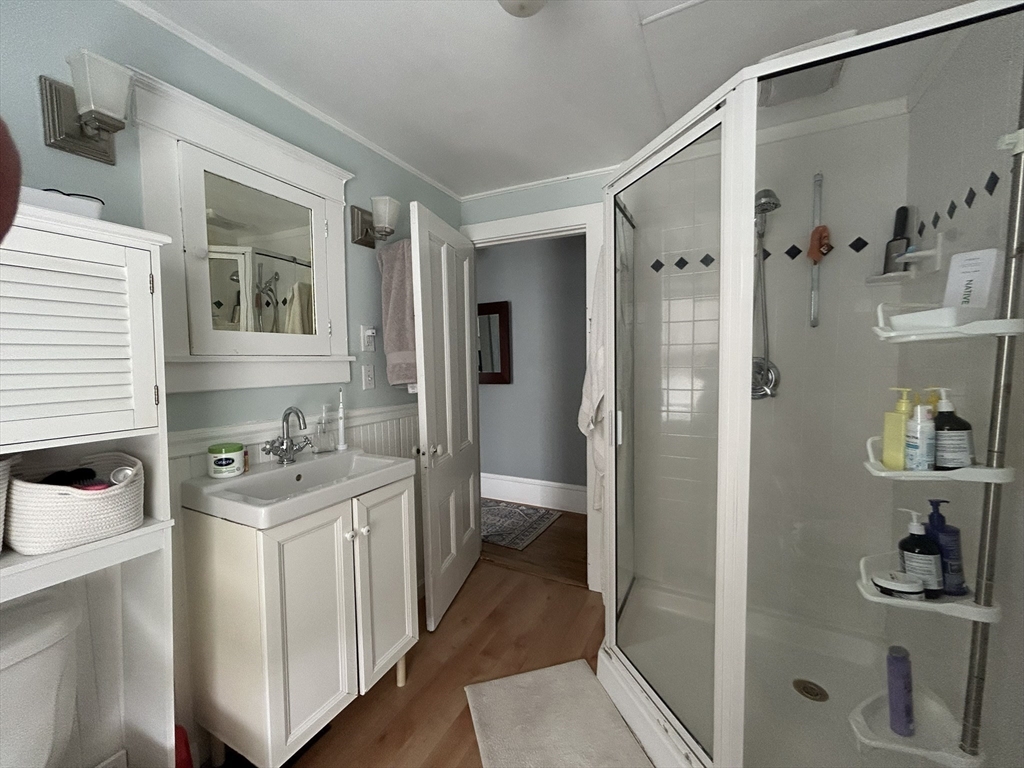 32 Parker Street, Unit 1 Lexington, MA 02421 - Photo 13 of 20 a bathroom with a granite countertop sink a refrigerator and a mirror