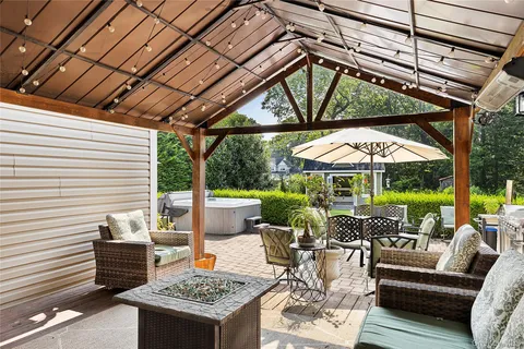 a swimming pool with outdoor seating and yard in the back