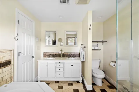 a bathroom with a tub sink and mirror