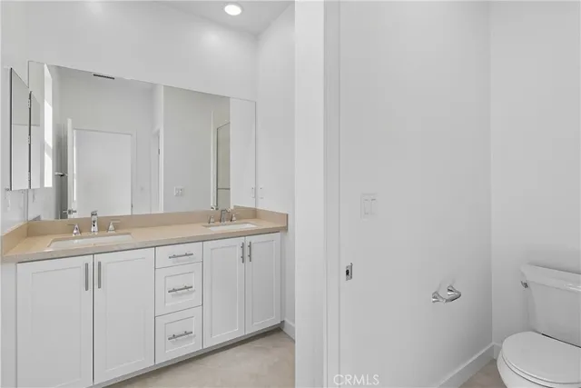 a bathroom with double sink and a mirror