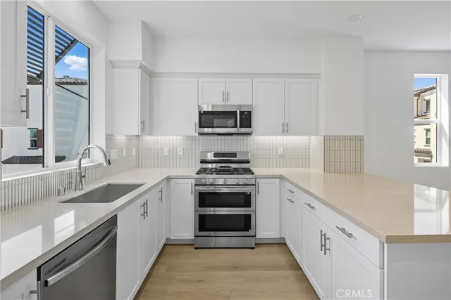 a kitchen with granite countertop a stove sink and dishwasher