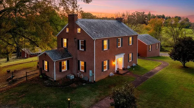 a front view of a house with yard and green space