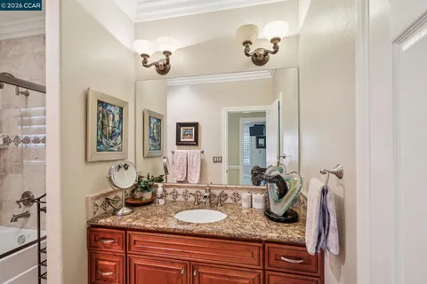 a spacious bathroom with a granite countertop double vanity sink and a mirror