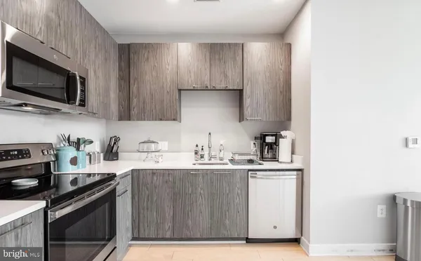 a kitchen with stainless steel appliances a sink cabinets and a refrigerator
