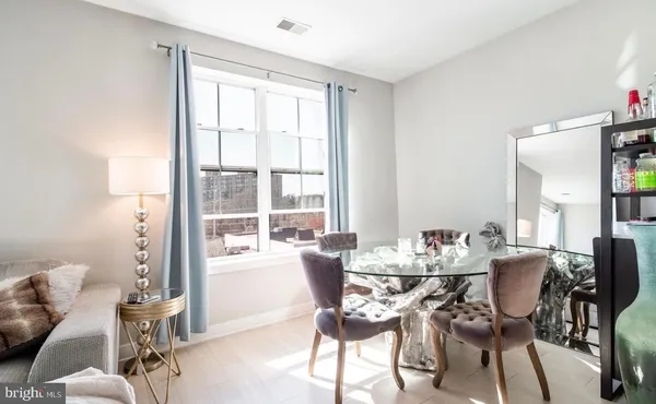 a living room with furniture kitchen appliances and a dining table