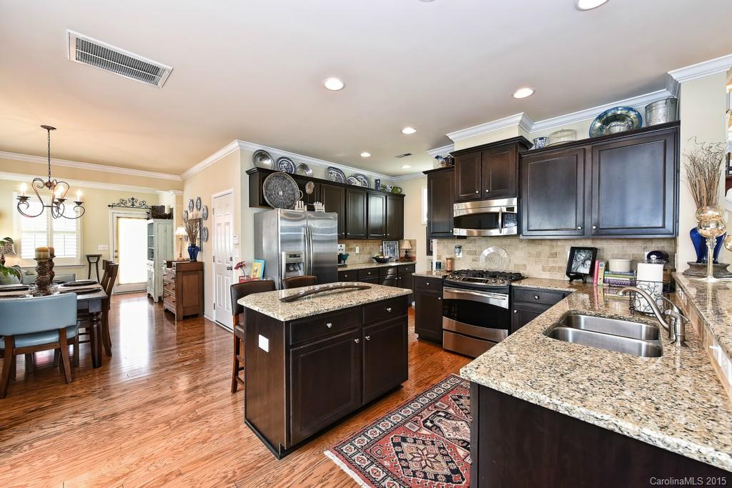 3446 Richard's Crossing Fort Mill, SC 29708 - Photo 5 of 15 a kitchen with stainless steel appliances granite countertop wooden cabinets a sink dishwasher and a stove top oven with wooden floor