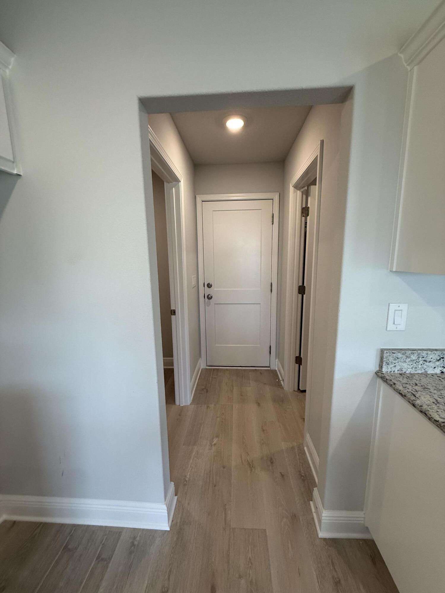 6002 Crocket Cove Crestview, FL 32539 - Photo 18 of 29 an empty room with wooden floor and a hallway