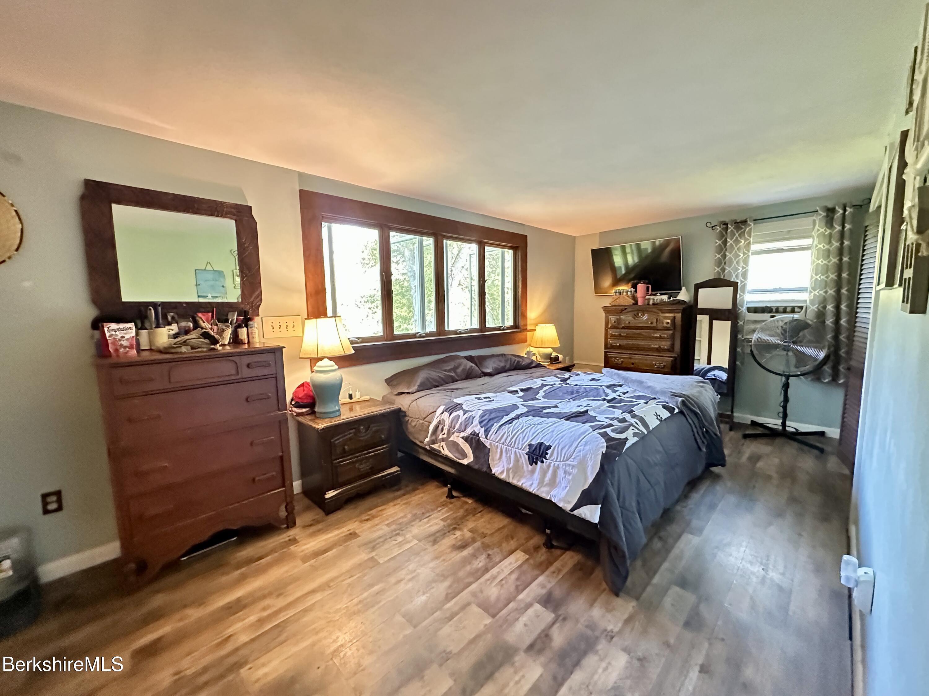 117 Norfolk Road New Marlborough, MA 01259 - Photo 13 of 16 a bedroom with a bed and wooden floor