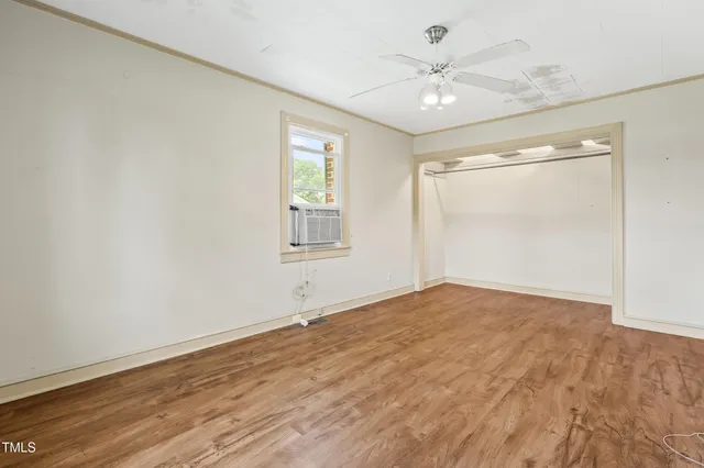 a view of a livingroom with wooden floor and a ceiling fan