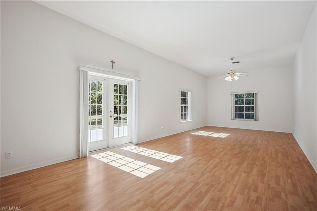5348 Cypress Lane Naples, FL 34113 - Photo 5 of 28 a view of an empty room with wooden floor and a window