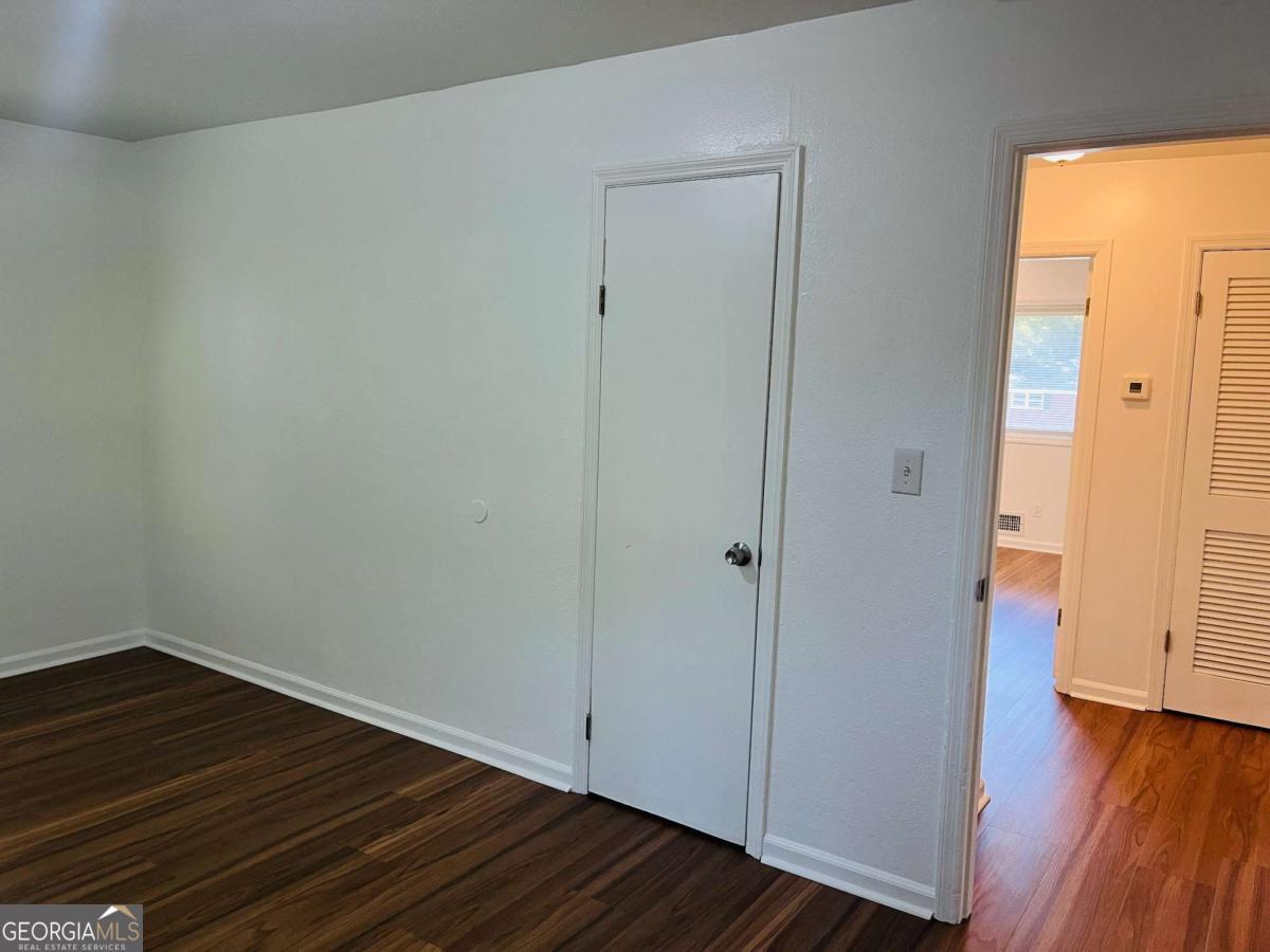 1076 Center Street Southwest, Unit 1074 Mableton, GA 30126 - Photo 13 of 26 a view of an empty room with wooden floor and a window