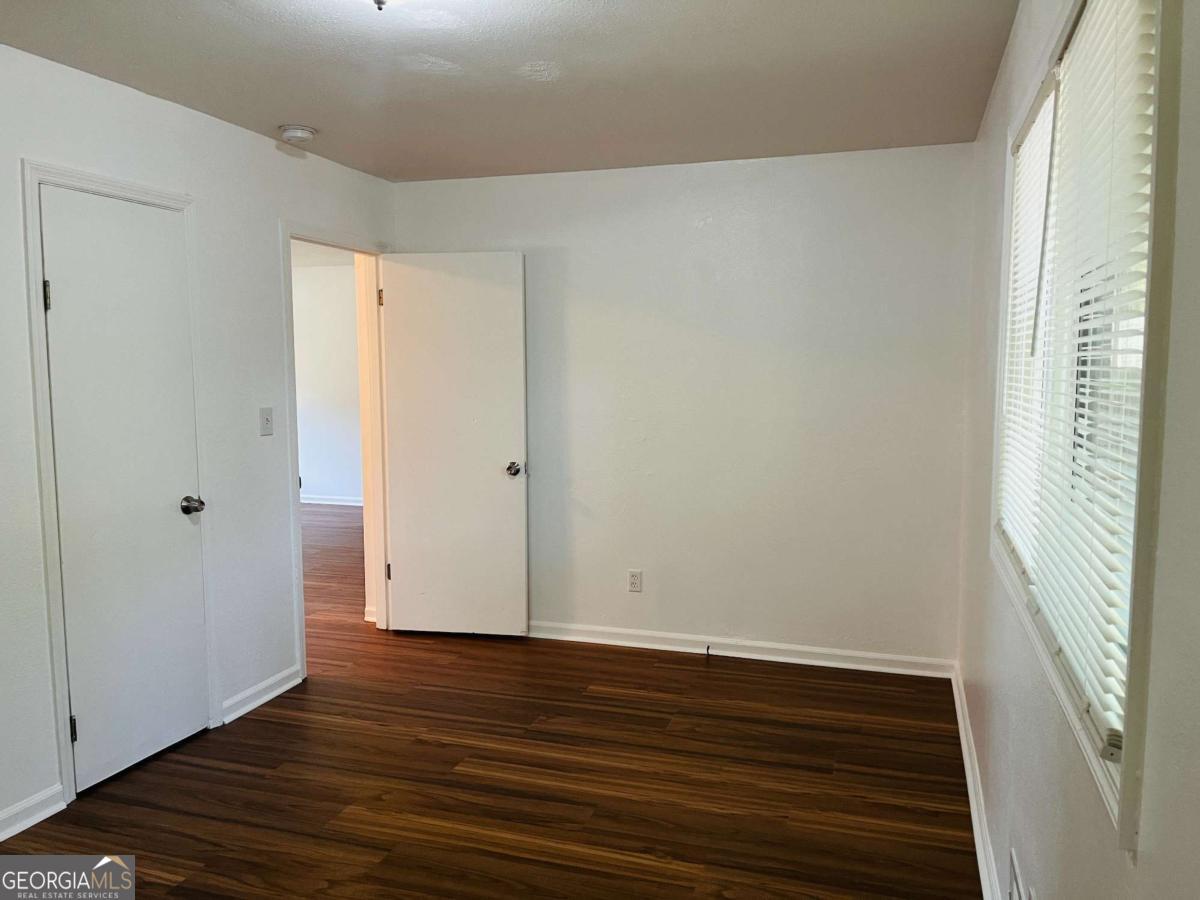 1076 Center Street Southwest, Unit 1074 Mableton, GA 30126 - Photo 15 of 26 a view of an empty room with wooden floor and a window
