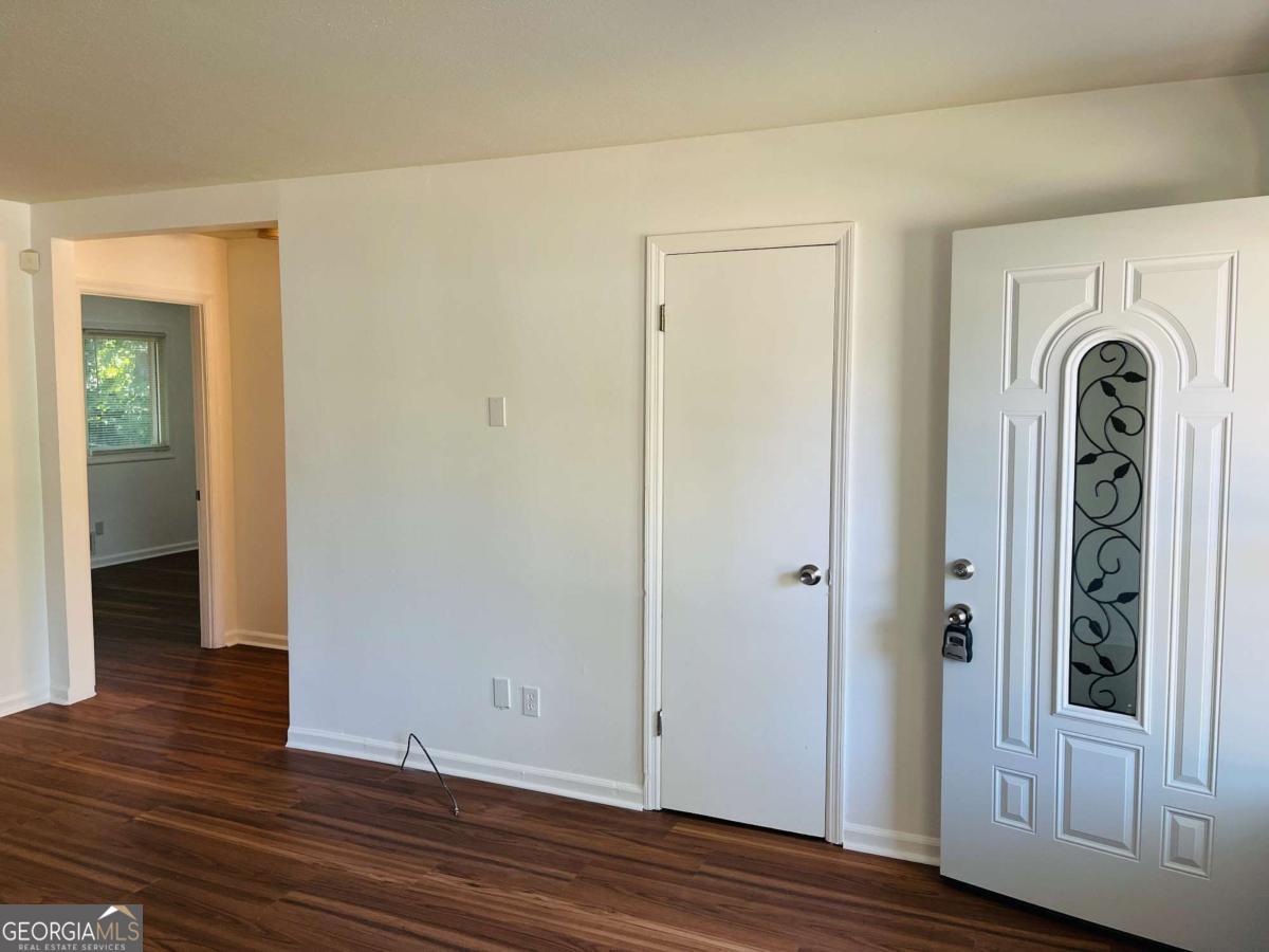 1076 Center Street Southwest, Unit 1074 Mableton, GA 30126 - Photo 5 of 26 an empty room with wooden floor and mirror