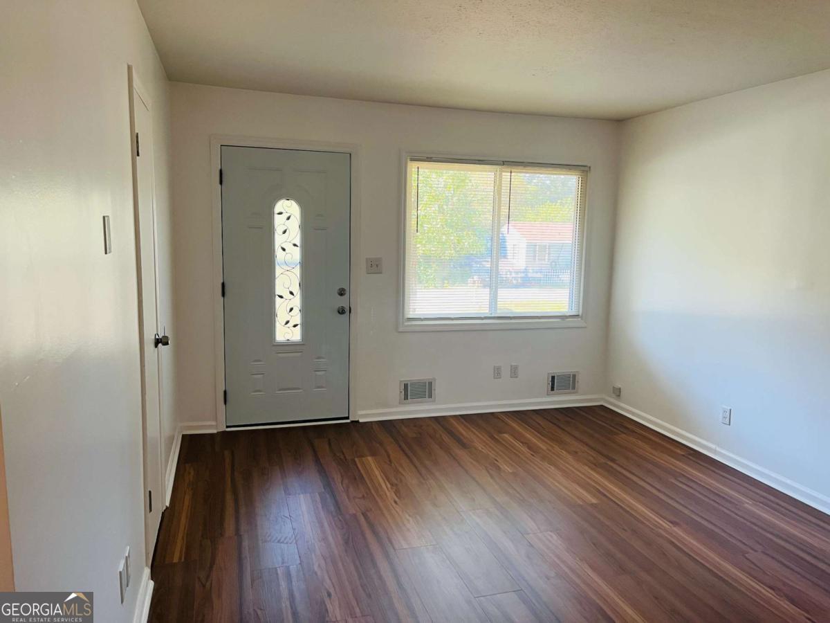 1076 Center Street Southwest, Unit 1074 Mableton, GA 30126 - Photo 6 of 26 an empty room with wooden floor and windows