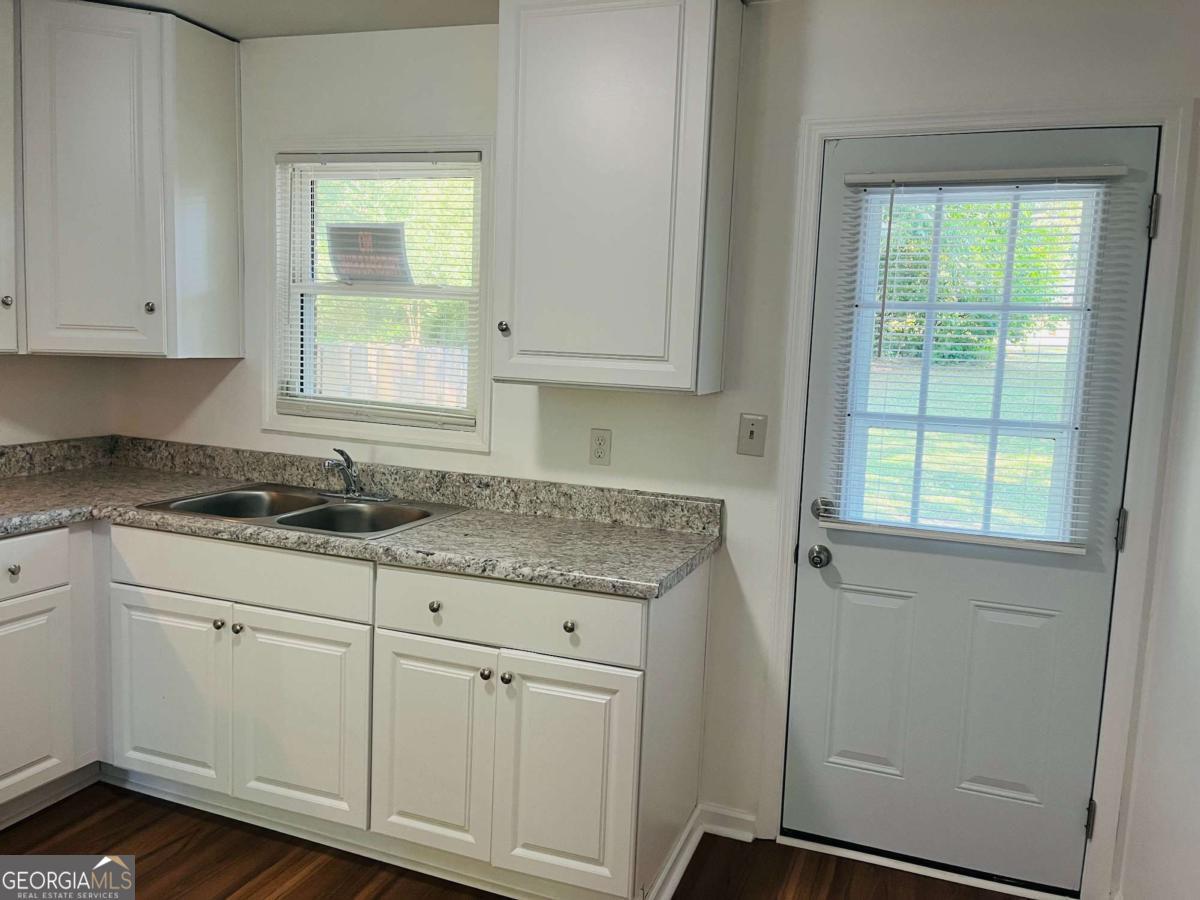 1076 Center Street Southwest, Unit 1074 Mableton, GA 30126 - Photo 9 of 26 a kitchen with granite countertop white cabinets and a sink