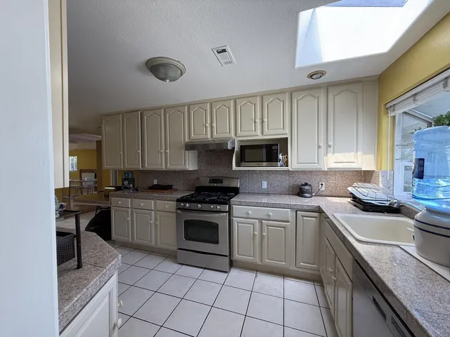 a kitchen with cabinets appliances a sink and a counter top space