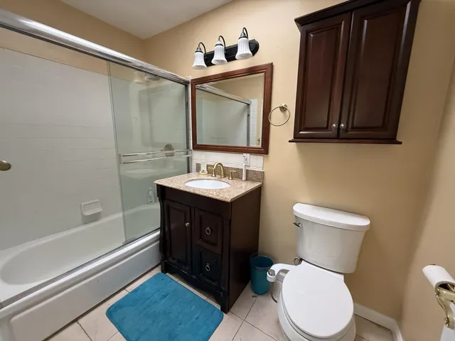 a bathroom with a sink vanity mirror and toilet