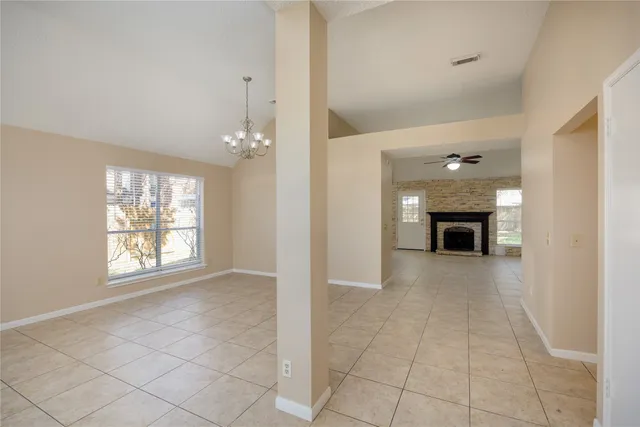 a view of an empty room with a fireplace and a window