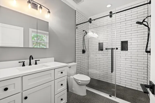 a bathroom with a toilet sink vanity and mirror