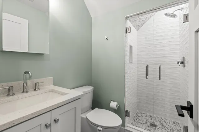 a bathroom with a sink a toilet and shower