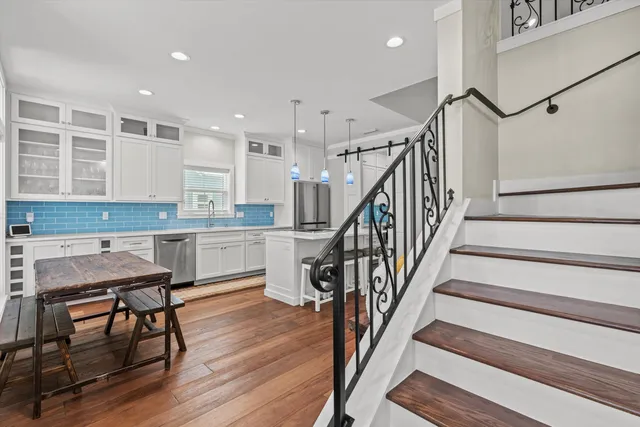 a kitchen with wooden floors and white cabinets