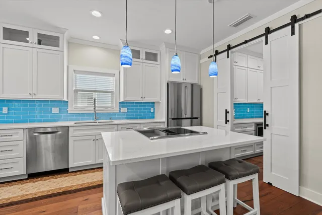 a kitchen with a table chairs refrigerator and microwave