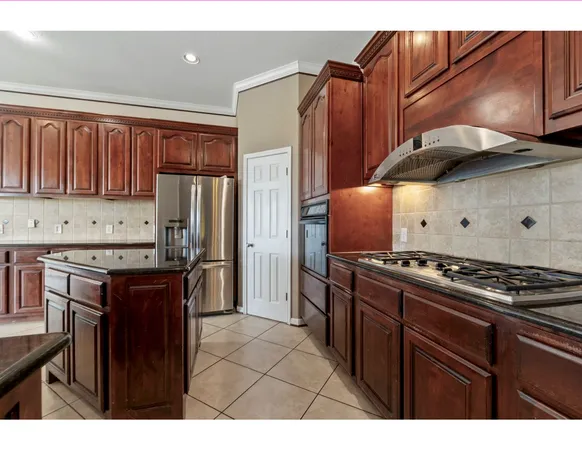 a kitchen with kitchen island granite countertop a sink cabinets and stainless steel appliances