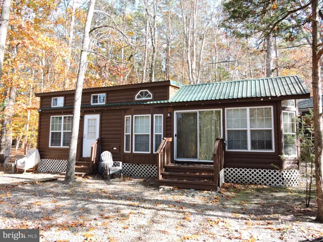 a front view of a house with a tree in front