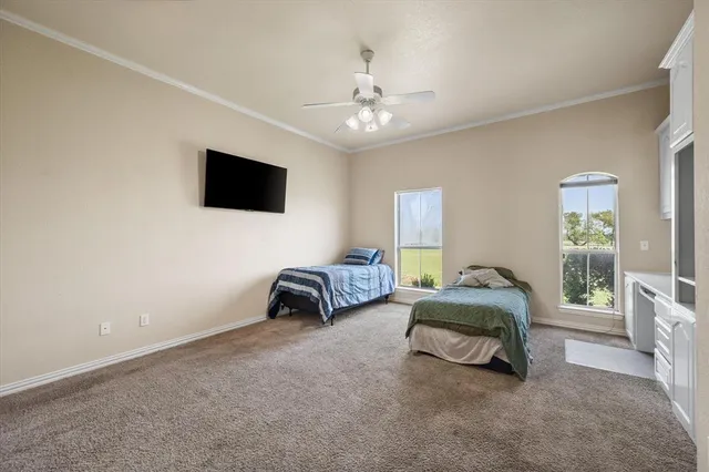 a spacious bedroom with a bed and a flat screen tv