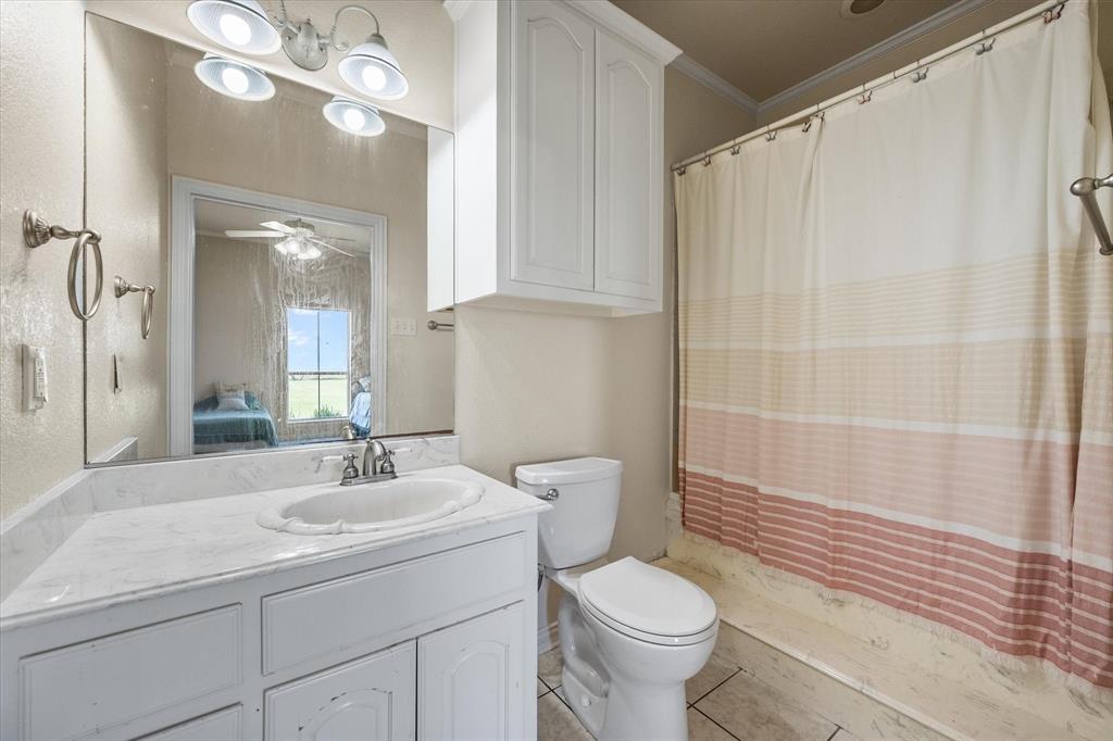14981 West State Highway Blooming Grove, TX 76626 - Photo 25 of 40 a bathroom with a sink a toilet and shower