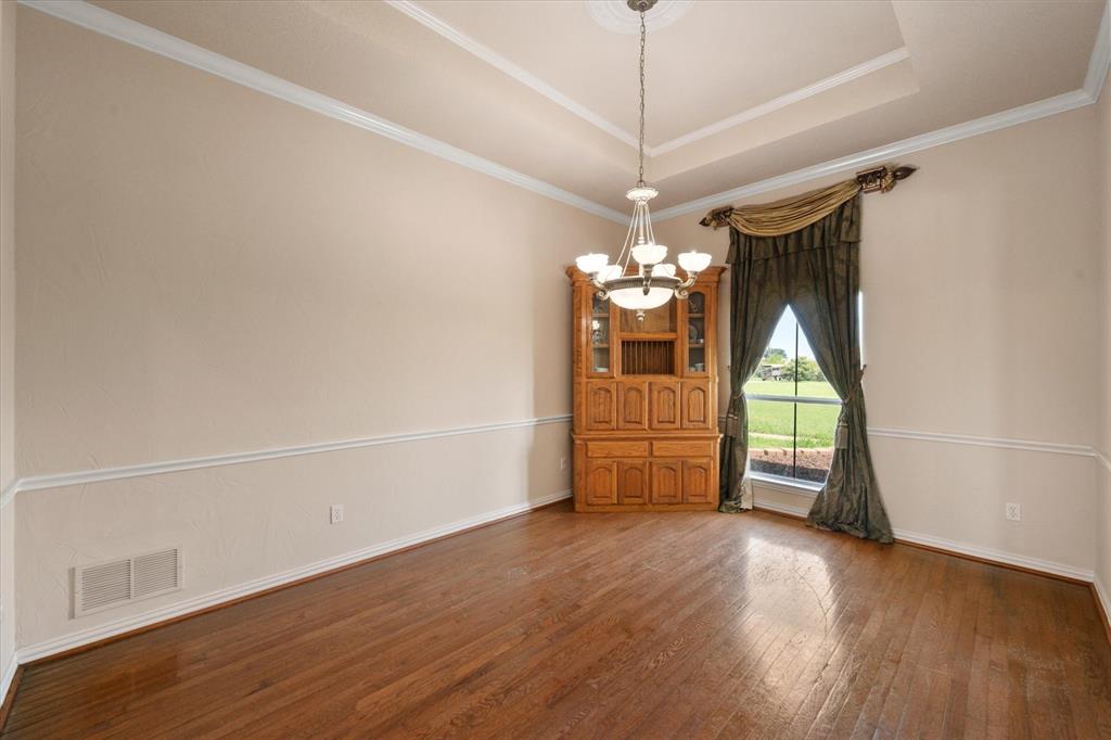 14981 West State Highway Blooming Grove, TX 76626 - Photo 6 of 40 an empty room with wooden floor chandelier and windows