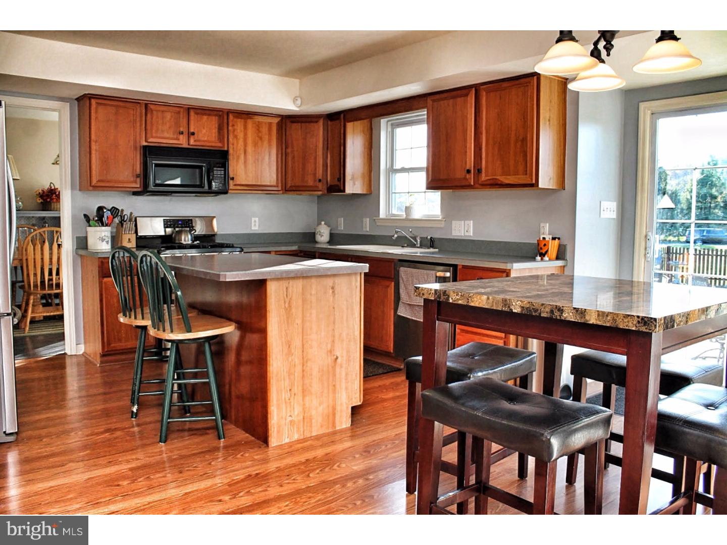 716 South Sandy Lane Sinking Spring, PA 19608 - Photo 3 of 19 a kitchen with stainless steel appliances granite countertop a stove top oven a refrigerator a dining table and chairs with wooden floor