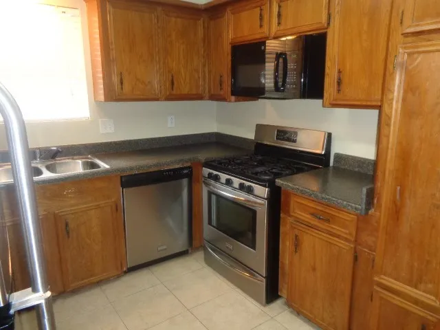 a kitchen with granite countertop a sink and a stove top oven