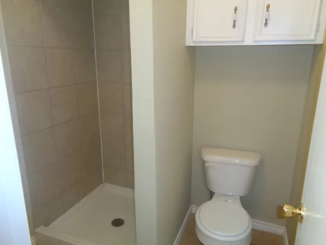 a bathroom with a toilet and a shower
