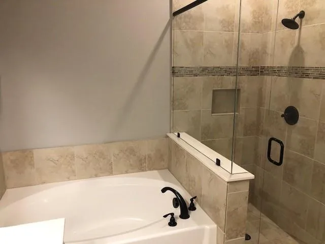 an empty room with wooden floor fireplace and windows