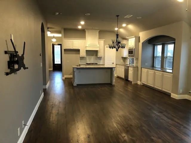 a large kitchen with lots of counter space wooden floor and appliances