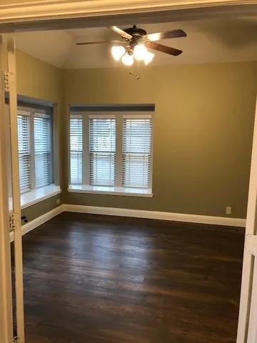 wooden floor fireplace and windows in an empty room