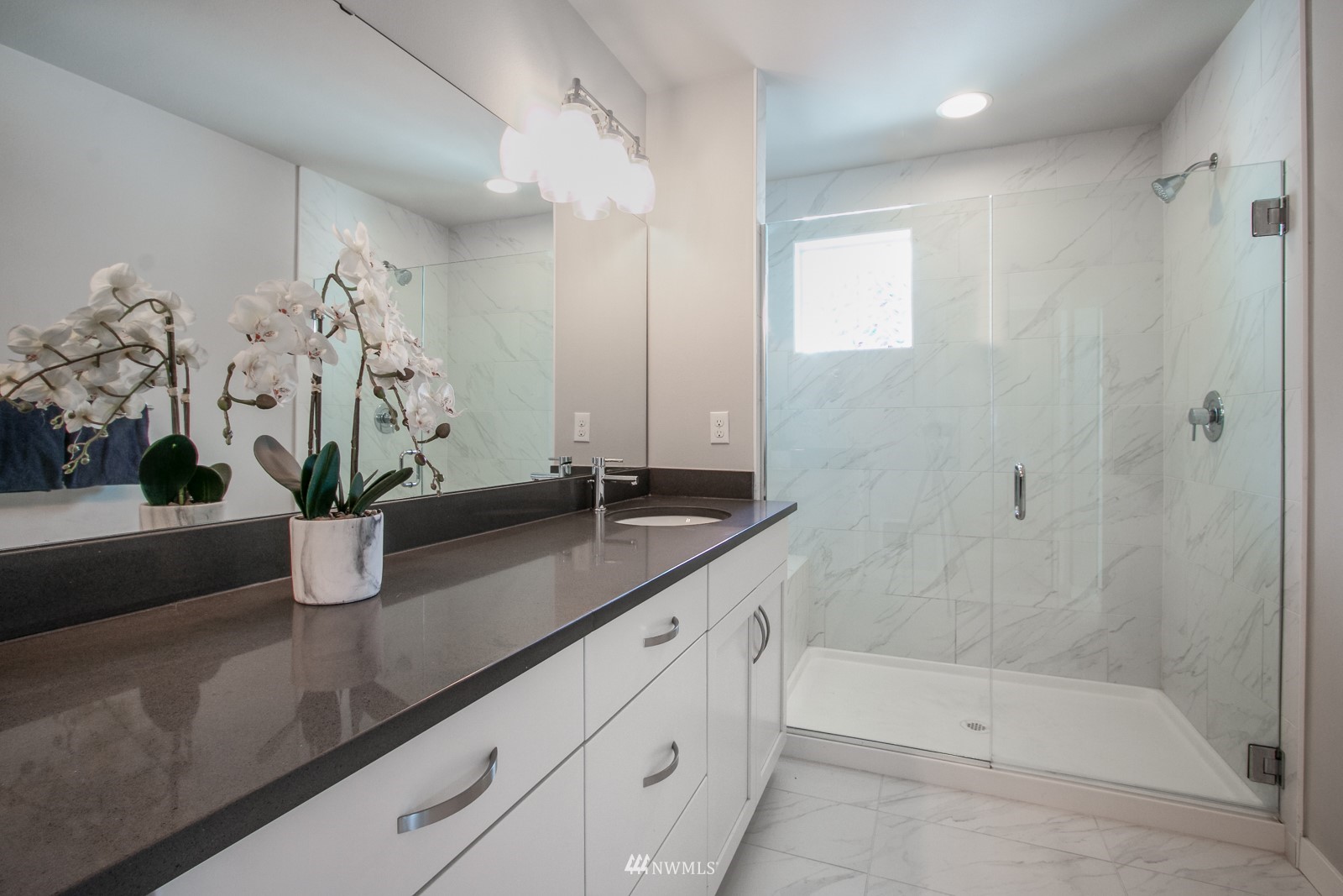 509 237th Place Southeast, Unit E Bothell, WA 98021 - Photo 30 of 35 a bathroom with a granite countertop sink a mirror a potted plant and a shower