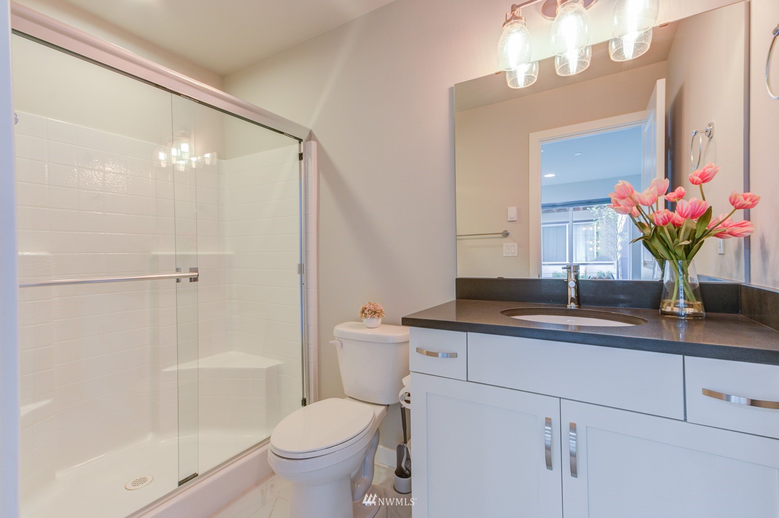 509 237th Place Southeast, Unit E Bothell, WA 98021 - Photo 8 of 35 a bathroom with a granite countertop sink a toilet and a mirror