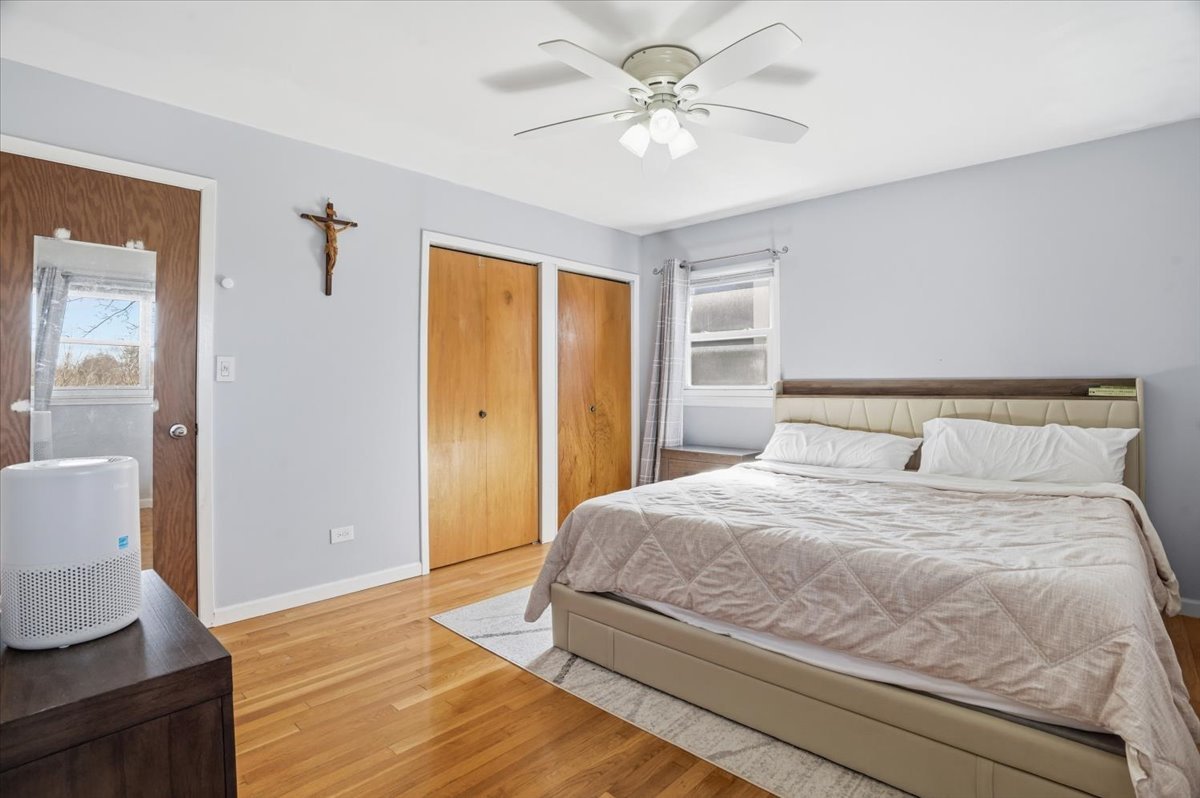 394 Northgate Road Lindenhurst, IL 60046 - Photo 14 of 28 a bedroom with a large bed a chandelier and closet