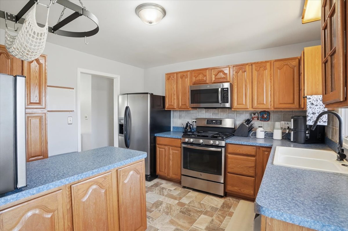 394 Northgate Road Lindenhurst, IL 60046 - Photo 10 of 28 a kitchen with stainless steel appliances granite countertop a stove a sink dishwasher a refrigerator and a microwave
