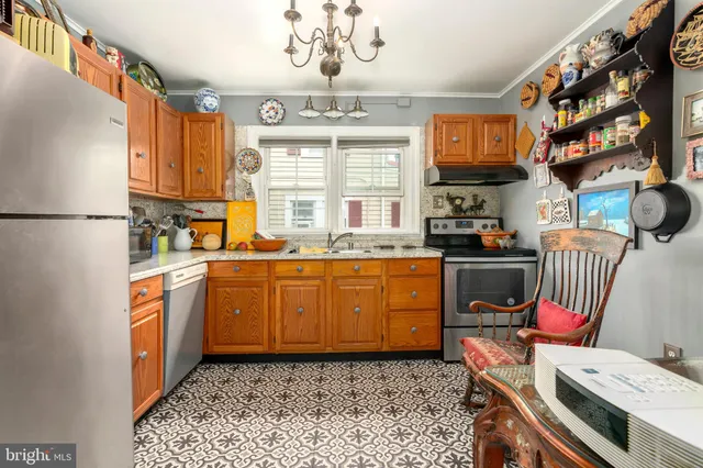 a kitchen with stainless steel appliances granite countertop a refrigerator a sink dishwasher a dining table and chairs with wooden floor