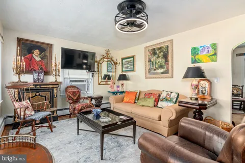 a living room with furniture a flat screen tv and a window