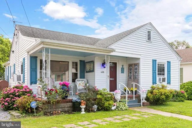 a front view of house and yard with beautiful flowers