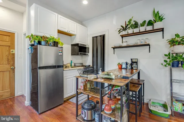 a kitchen with stainless steel appliances a refrigerator and a table