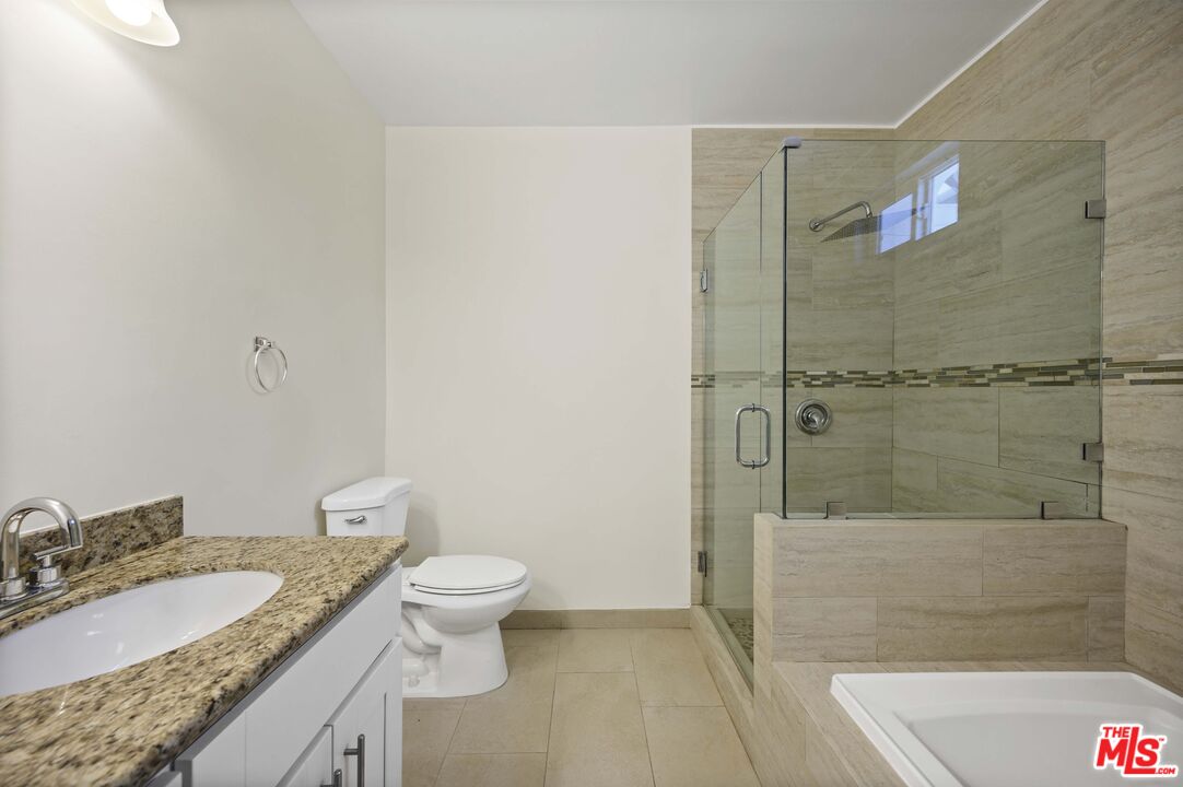 2148 Kelton Avenue Los Angeles, CA 90025 - Photo 16 of 36 a bathroom with a granite countertop sink a toilet and shower