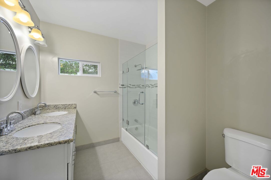 2148 Kelton Avenue Los Angeles, CA 90025 - Photo 22 of 36 a bathroom with a granite countertop sink toilet and shower