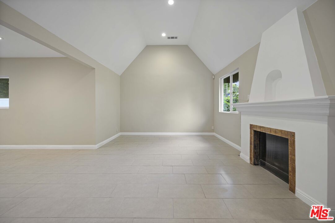 2148 Kelton Avenue Los Angeles, CA 90025 - Photo 4 of 36 a view of an empty room with a fireplace and a window