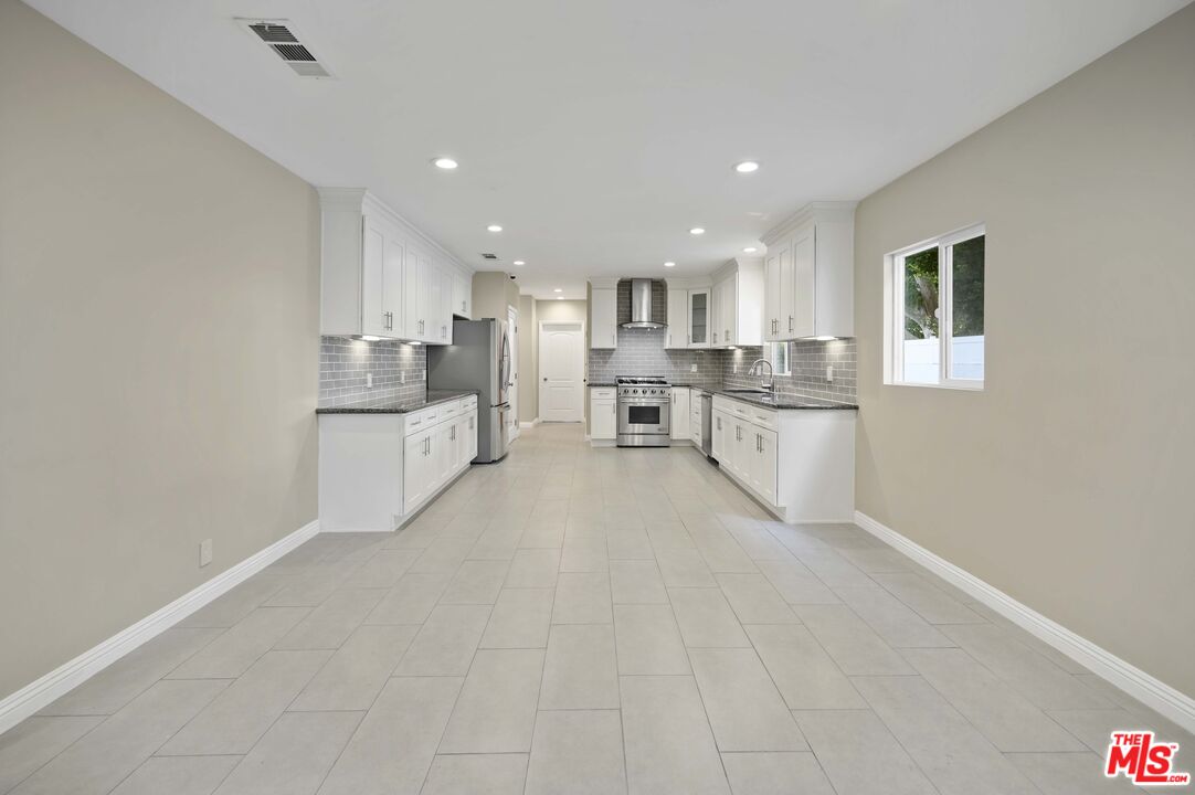2148 Kelton Avenue Los Angeles, CA 90025 - Photo 7 of 36 a large white kitchen with lots of counter space and windows