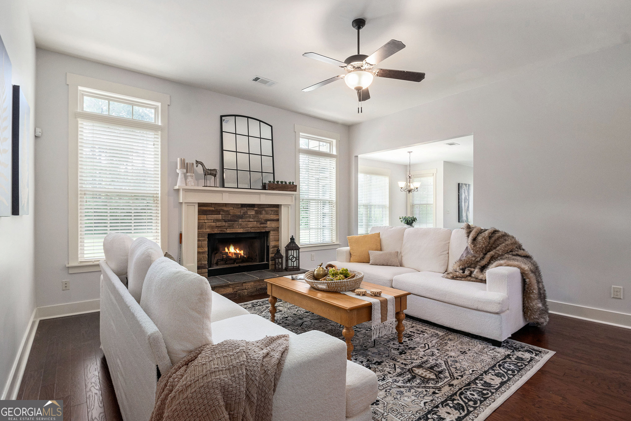 466 Austin Storey Circle Newnan, GA 30263 - Photo 5 of 38 a living room with furniture a chandelier and a fireplace
